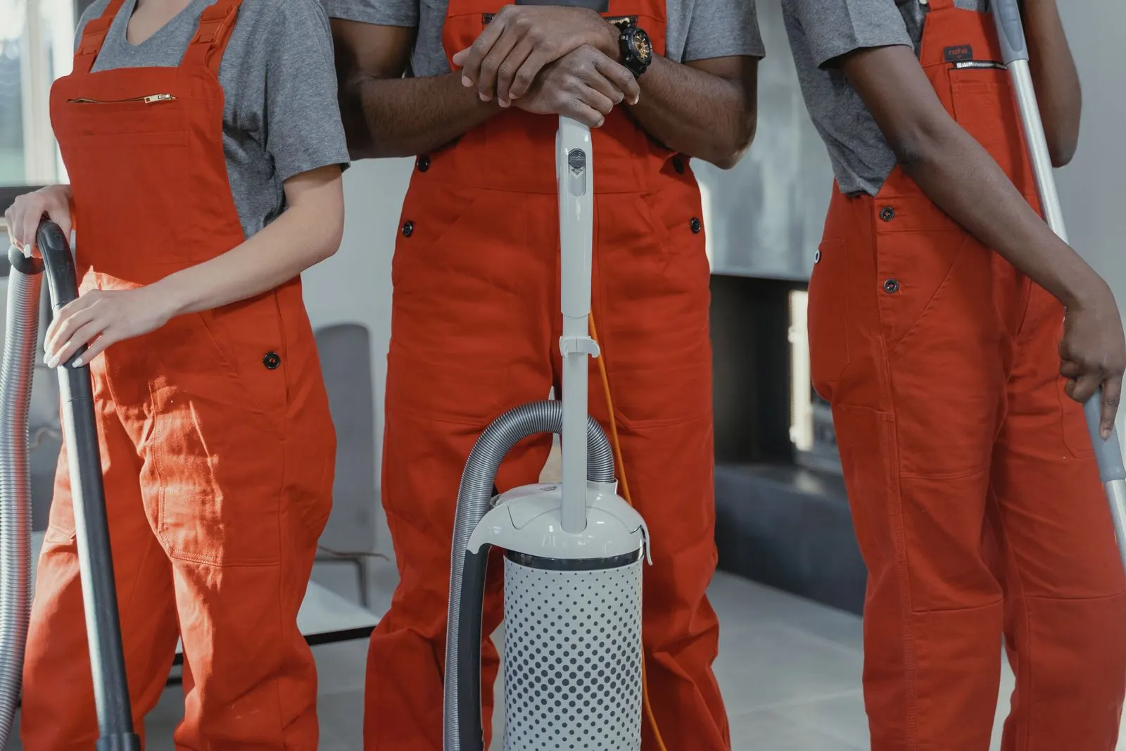 Alicia's Janitorial cleaning team in uniform with vacuums and supplies
