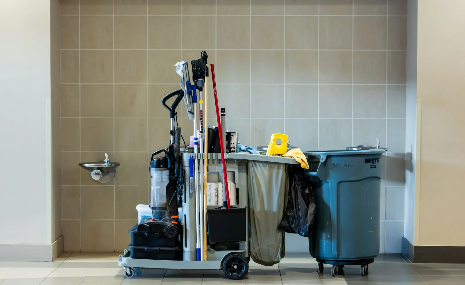 Fully stocked janitorial cart with mops, bags, and supplies