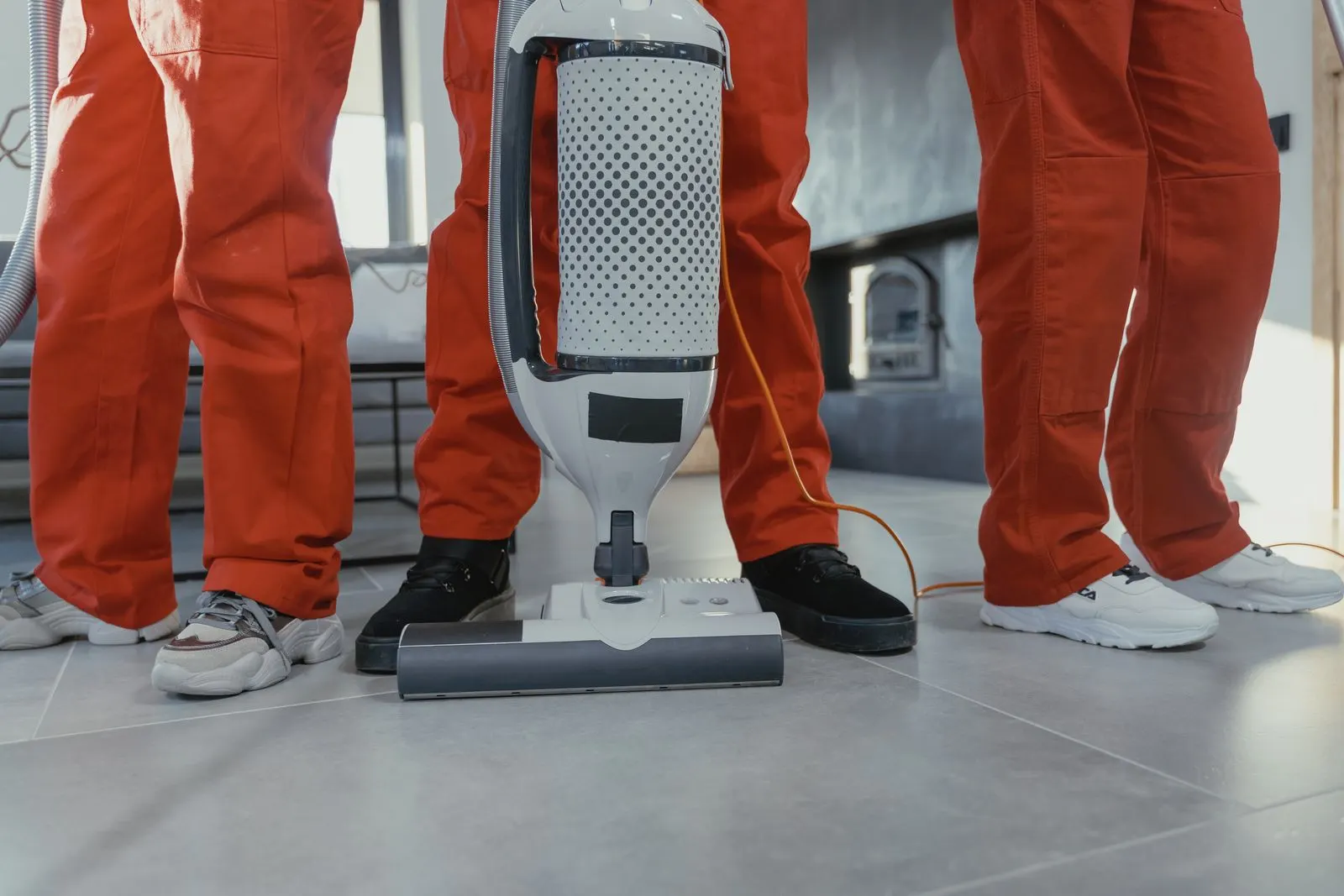 Cleaning team in matching uniforms with a vacuum ready for a scheduled visit