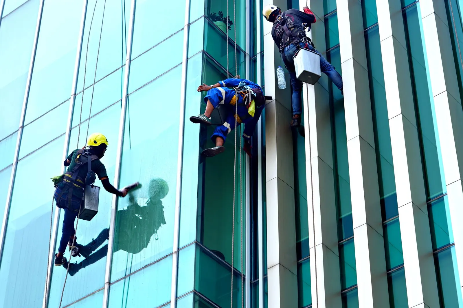 Cleaners washing the glass facade of a modern building